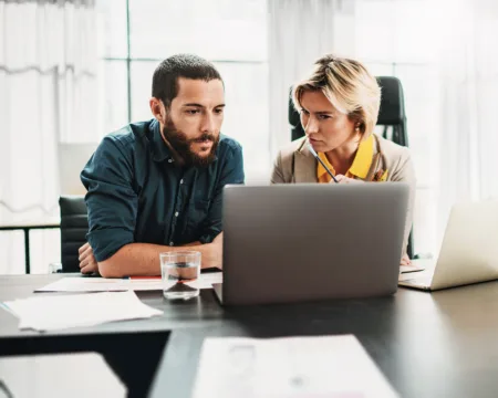 Ein Mann und eine Frau besprechen am Laptop die Datenanalyse und Betriebsoptimierung