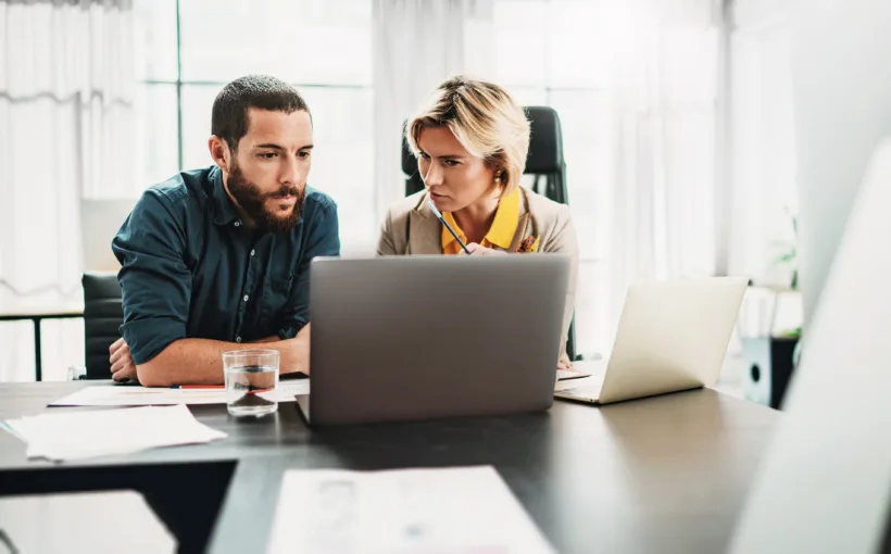 Ein Mann und eine Frau besprechen am Laptop die Datenanalyse und Betriebsoptimierung