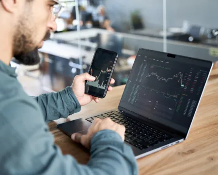 Ein Mitarbeiter prüft die Möglichkeiten von Marktstrom via Smartphone und Laptop.